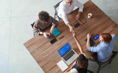 Four people sat round desk working