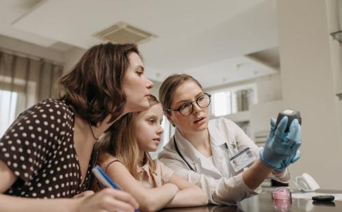 Mother and daughter checking a glucometer