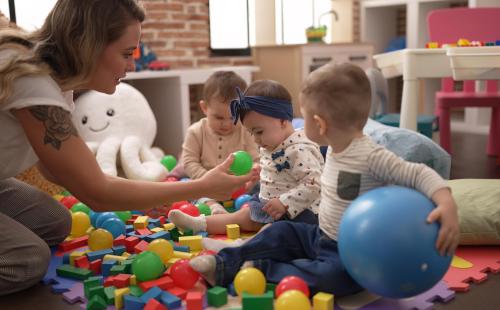 Teacher and preschool students playing with balls