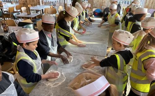 Children from Booth Wood Academy trying out pizza making on a restaurant visit