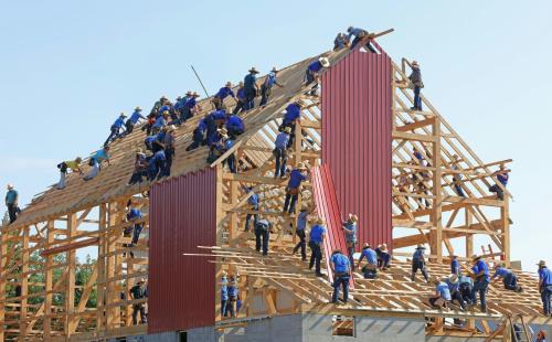 House under construction with dozens of workers