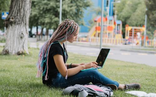 Teenage student in the park with a laptop