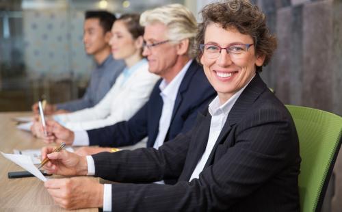 Board meeting with smiling woman facing the camera