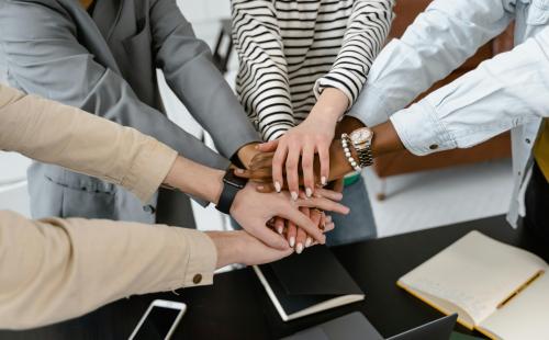 People gathered round linking hands
