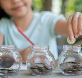 Child putting money in jars - Freepik / jcomp