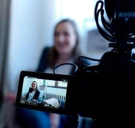 Person being interview in front of a video camera