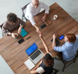 Four people sat round desk working