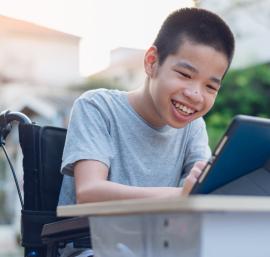 Pupil in a wheelchair using a laptop
